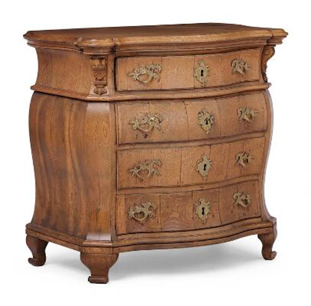 Danish rococo chest of drawers of oak, bombé shaped with four drawers.