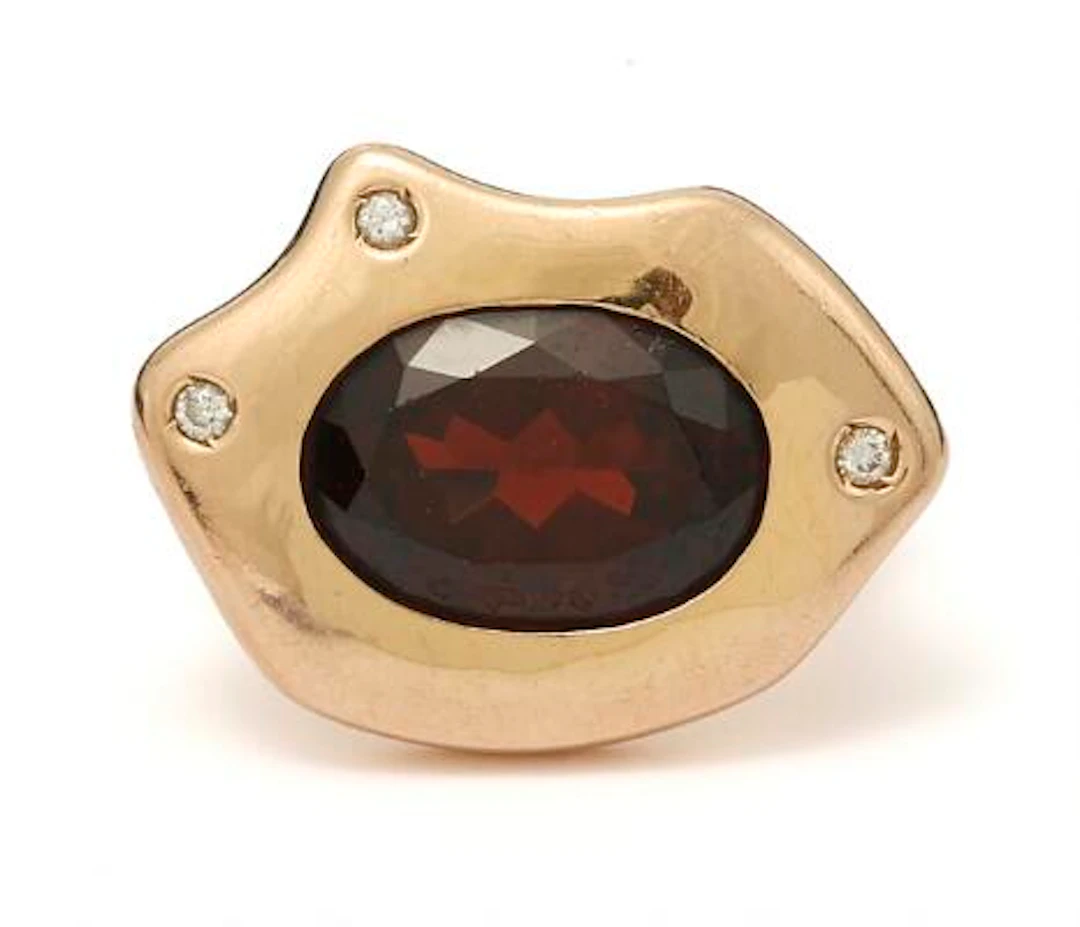 A garnet ring set with a garnet and diamonds, mounted in 14k gold.