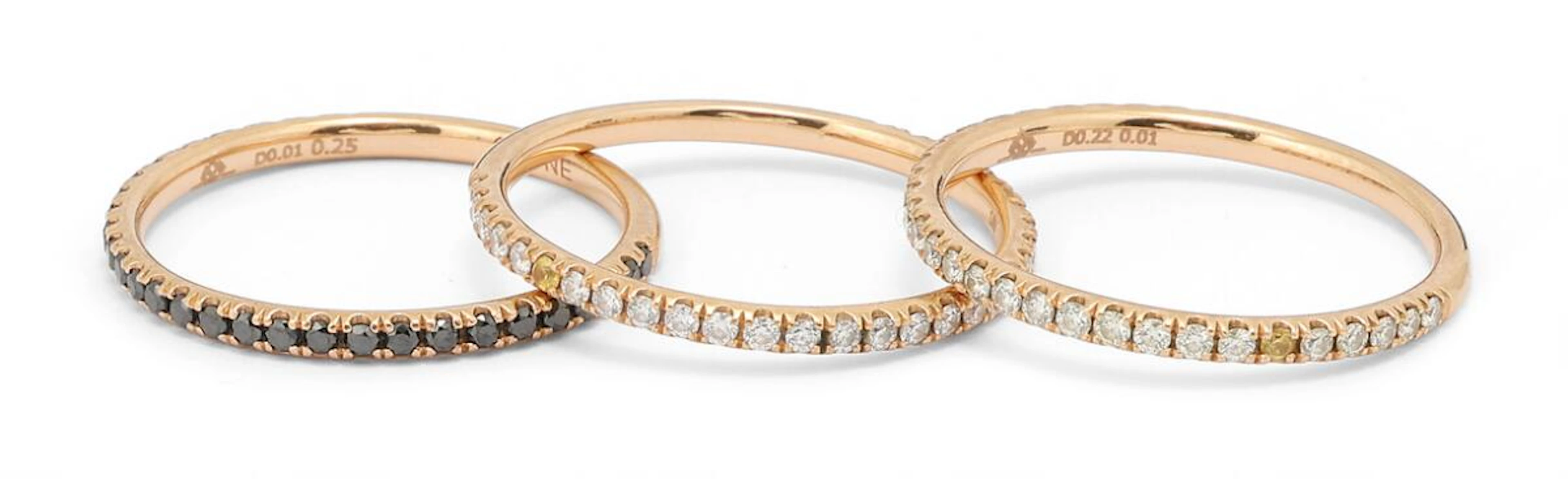 A collection of three diamond rings set with black and white diamonds