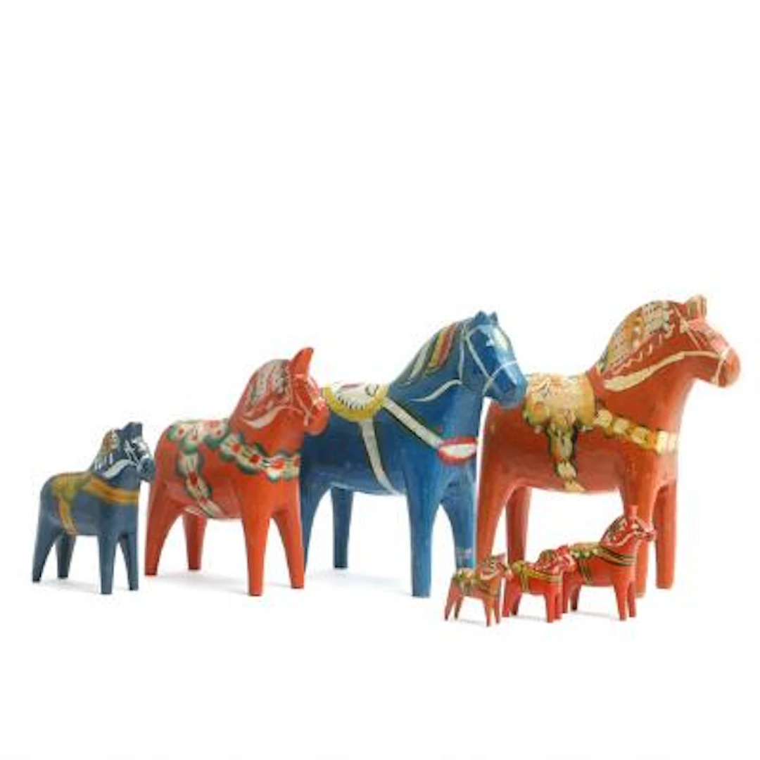 Collection of seven Dala horses of carved wood, decorated in orange-red