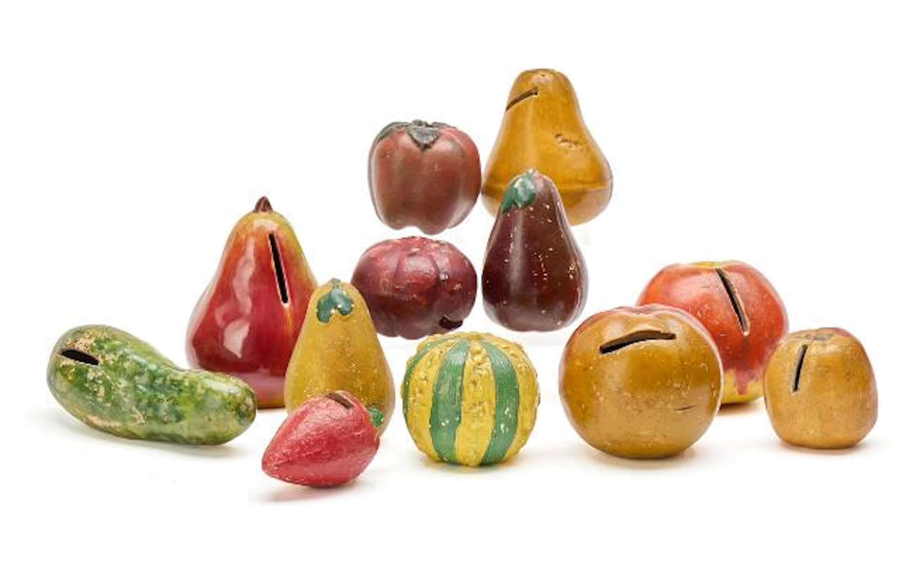 A collection of money boxes in the form of fruit. Primarily glazed