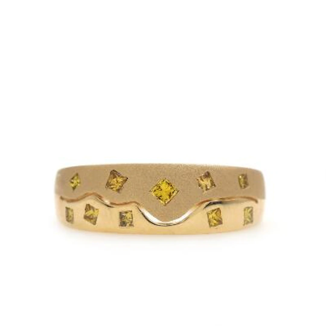 A diamond ring set with princess-cut yellow diamonds weighing a total