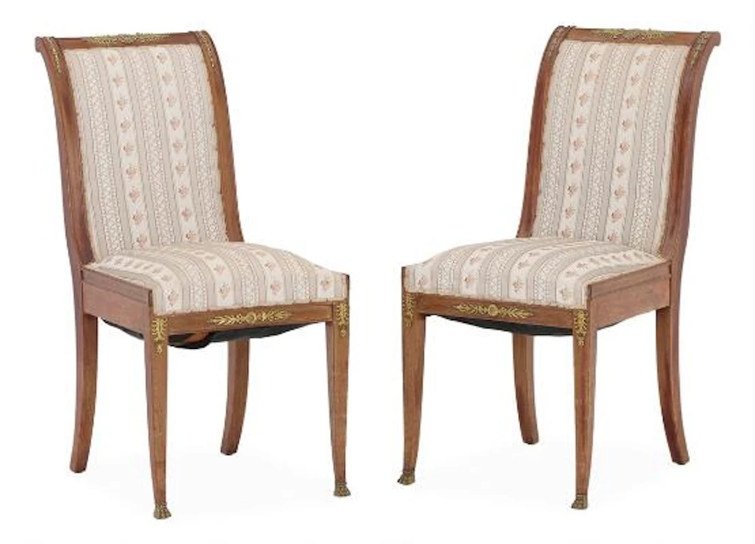 A pair of French Empire style mahogany chairs with gilt bronze fittings.