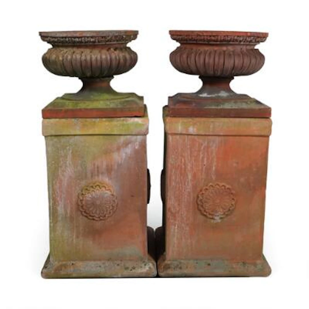 A pair of terracotta garden urns with fluting. Mounted on four-sided