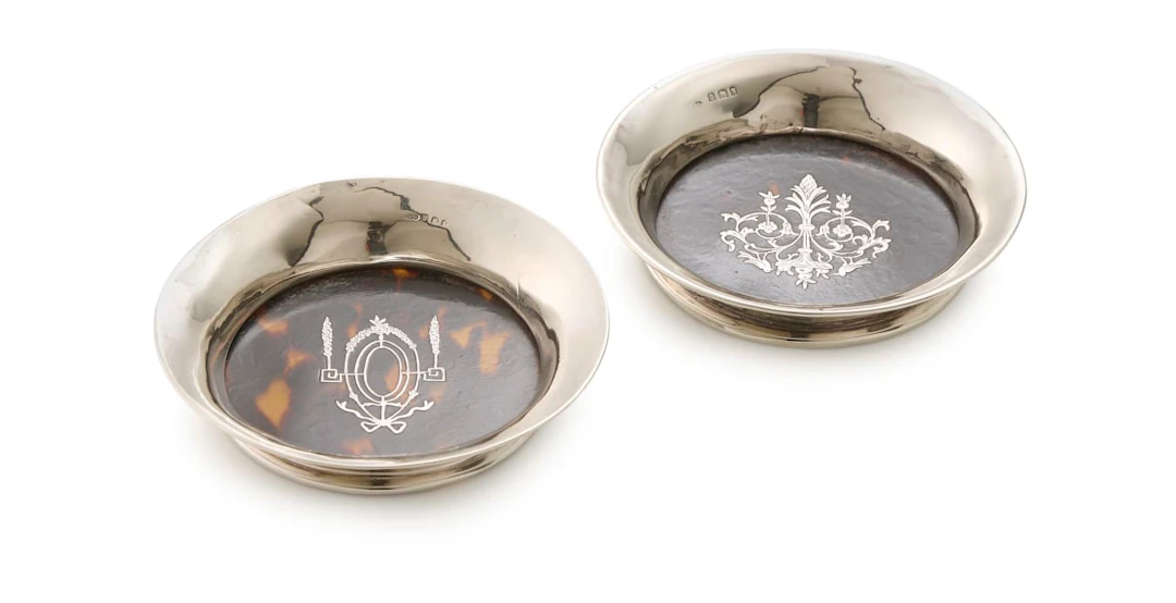 A near pair of George V silver-mounted and tortoiseshell coasters