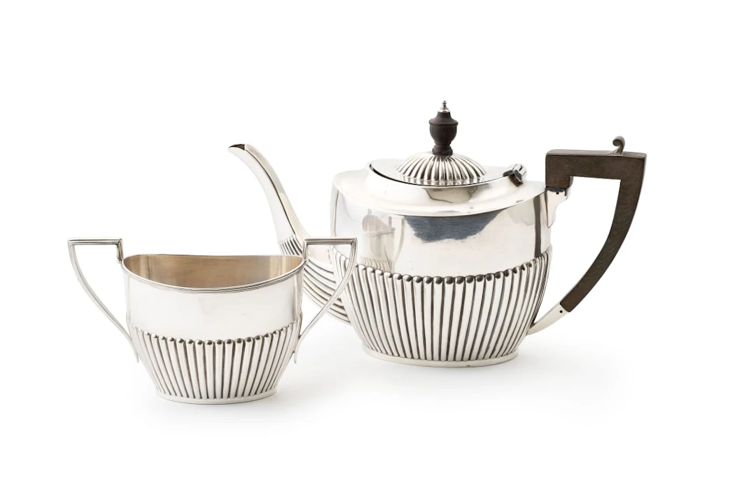 An assembled Edward VII silver teapot and silver-plated sugar basin
