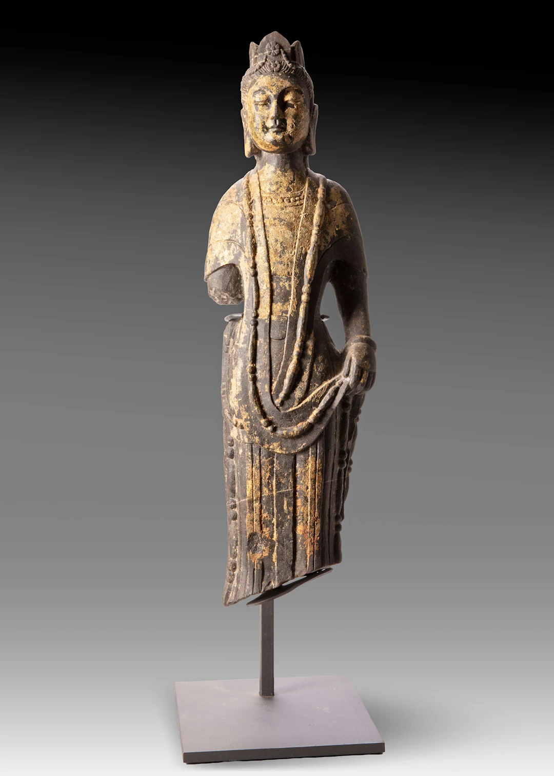 A FINELY CARVED STONE FIGURE OF A STANDING BUDDHIST DEITY