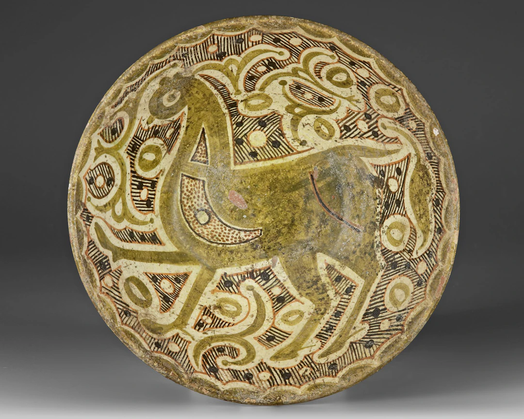 A NISHAPUR SLIP-PAINTED POTTERY BOWL, PERSIA, 10TH-11TH CENTURY