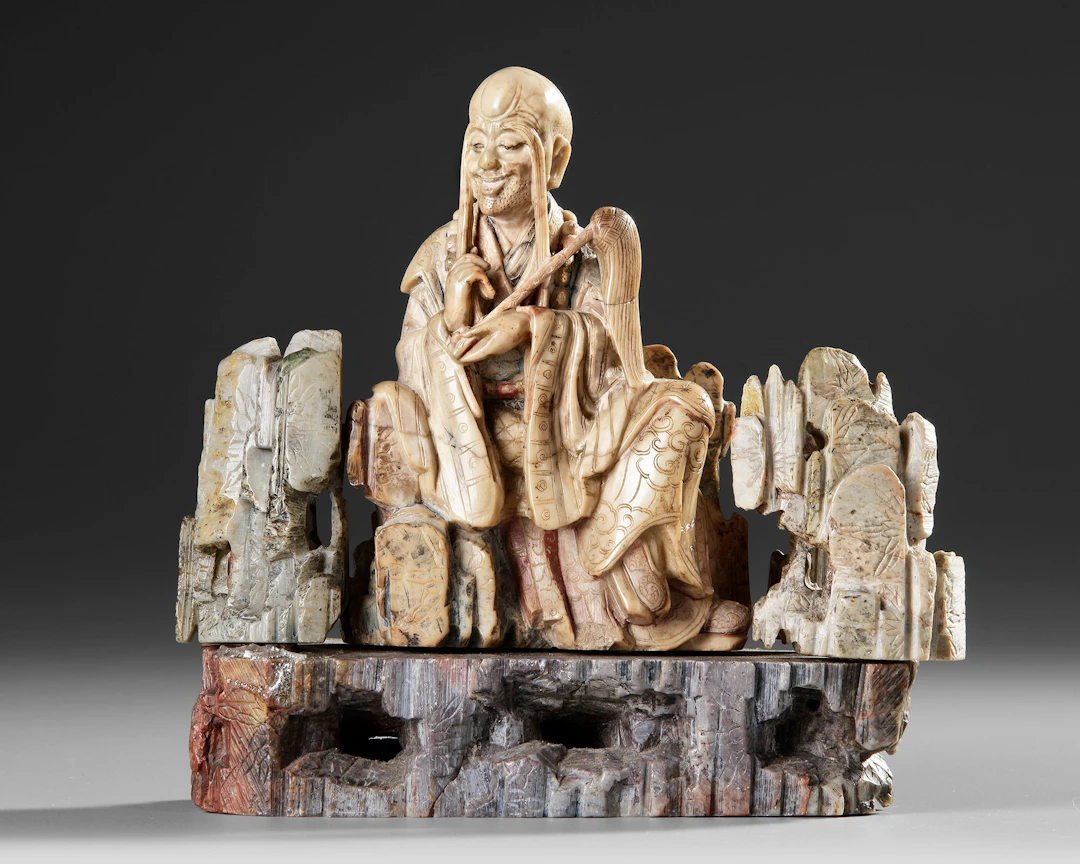 A CHINESE SOAPSTONE FIGURE OF A DAOIST IMMORTAL, 19TH CENTURY