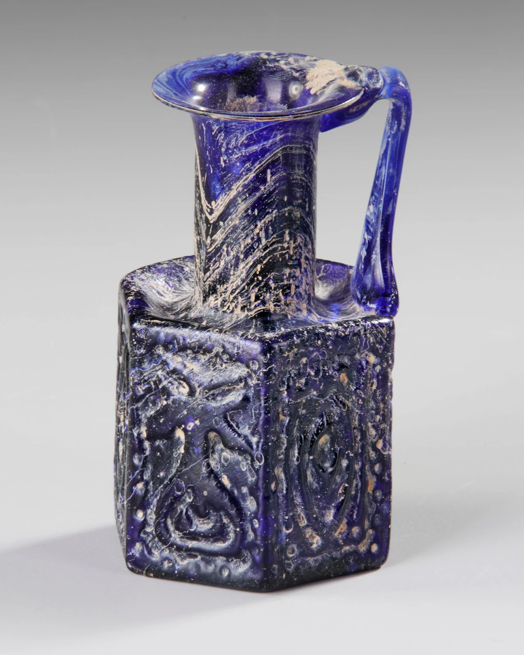 A COBALT BLUE MOLDED GLASS JUGLET, EASTERN MEDITERRANEAN, 1ST–3RD CENTURY AD