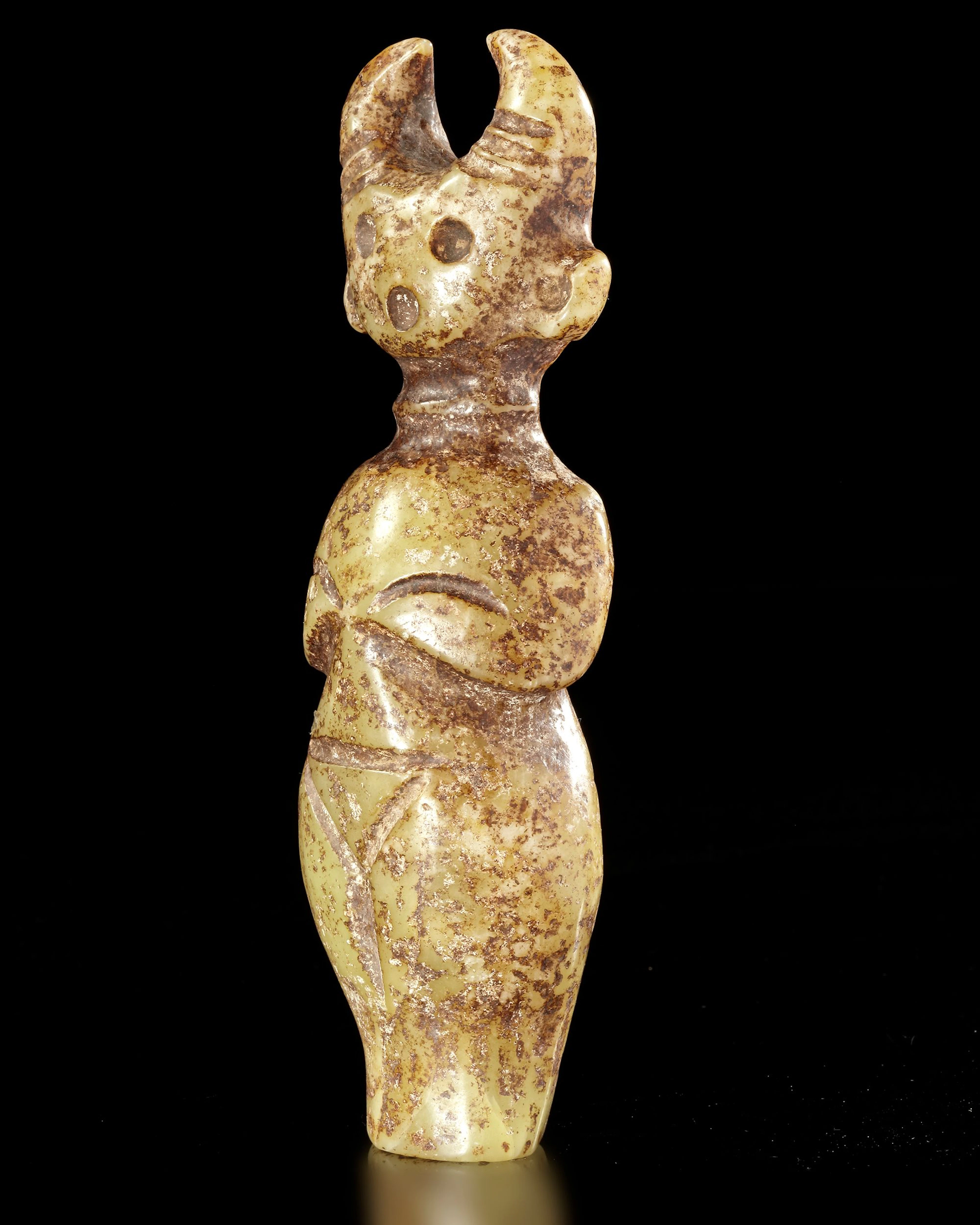A GREENISH-YELLOW JADE CARVING OF A HORNED STANDING FIGURE, CHINA