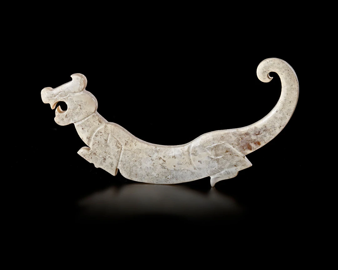 A CHINESE TIGER-SHAPED JADE PLAQUE, POST–SHIJIAHE CULTURE (c.2000 BC-1800 BC)