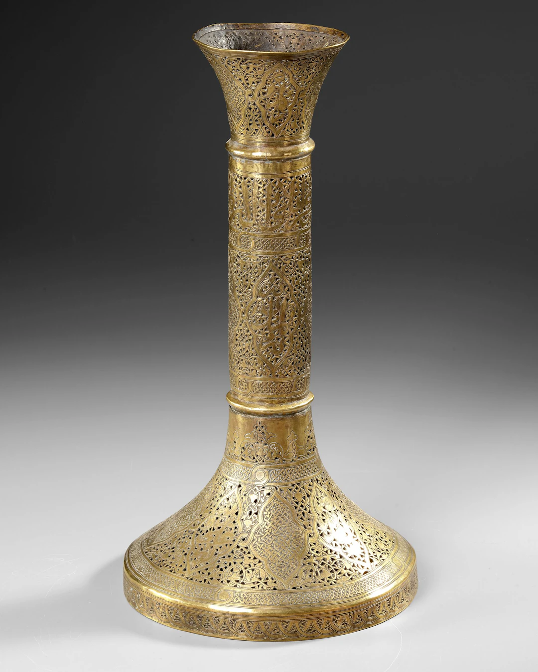 A QAJAR PIERCED BRASS CANDLESTICK, PERSIA, 19TH CENTURY