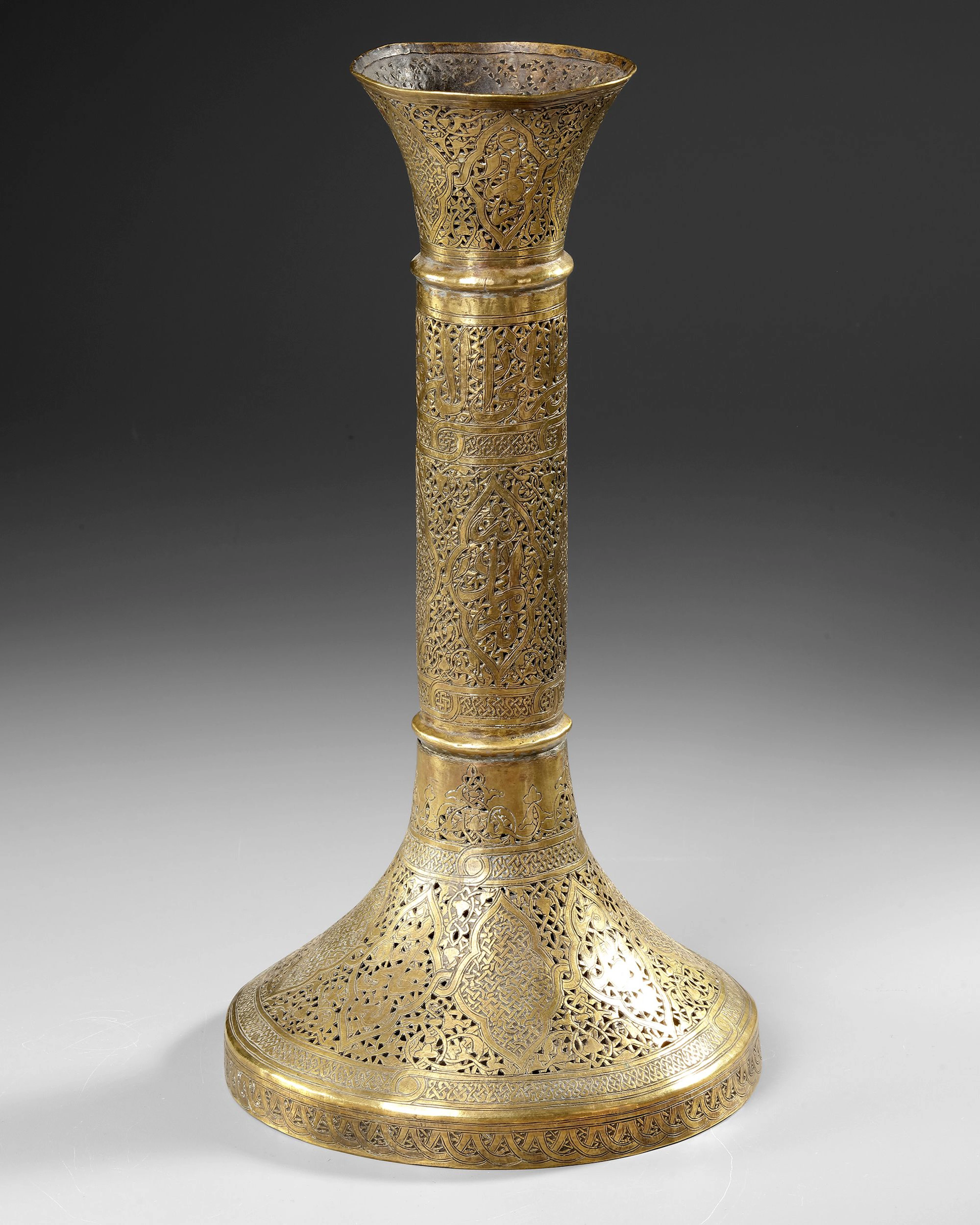 A QAJAR PIERCED BRASS CANDLESTICK, PERSIA, 19TH CENTURY