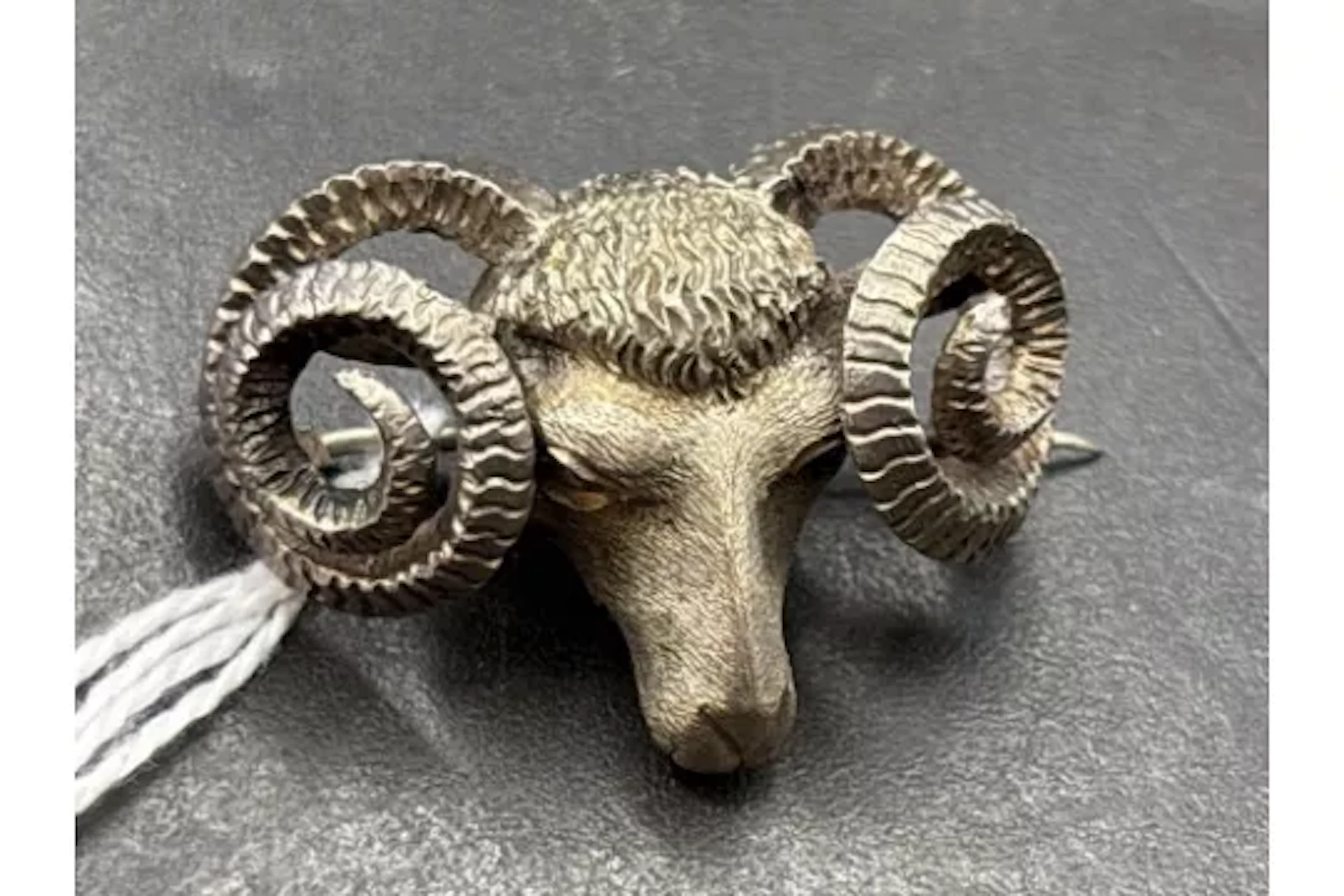 A silver rams head brooch