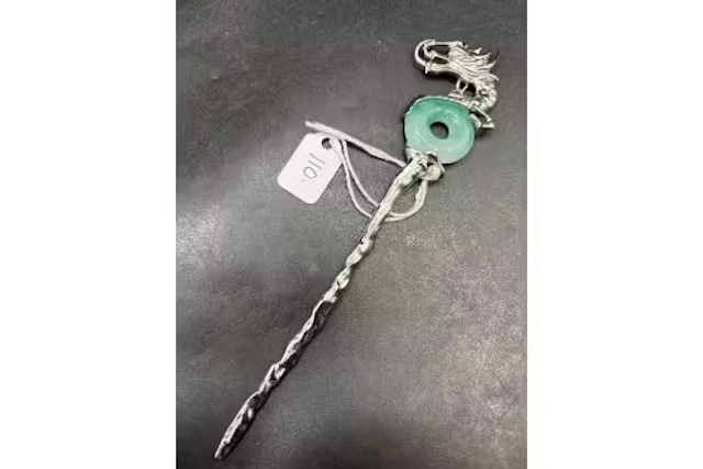 A unusual white metal hat pin with jade hard stone and dragon top