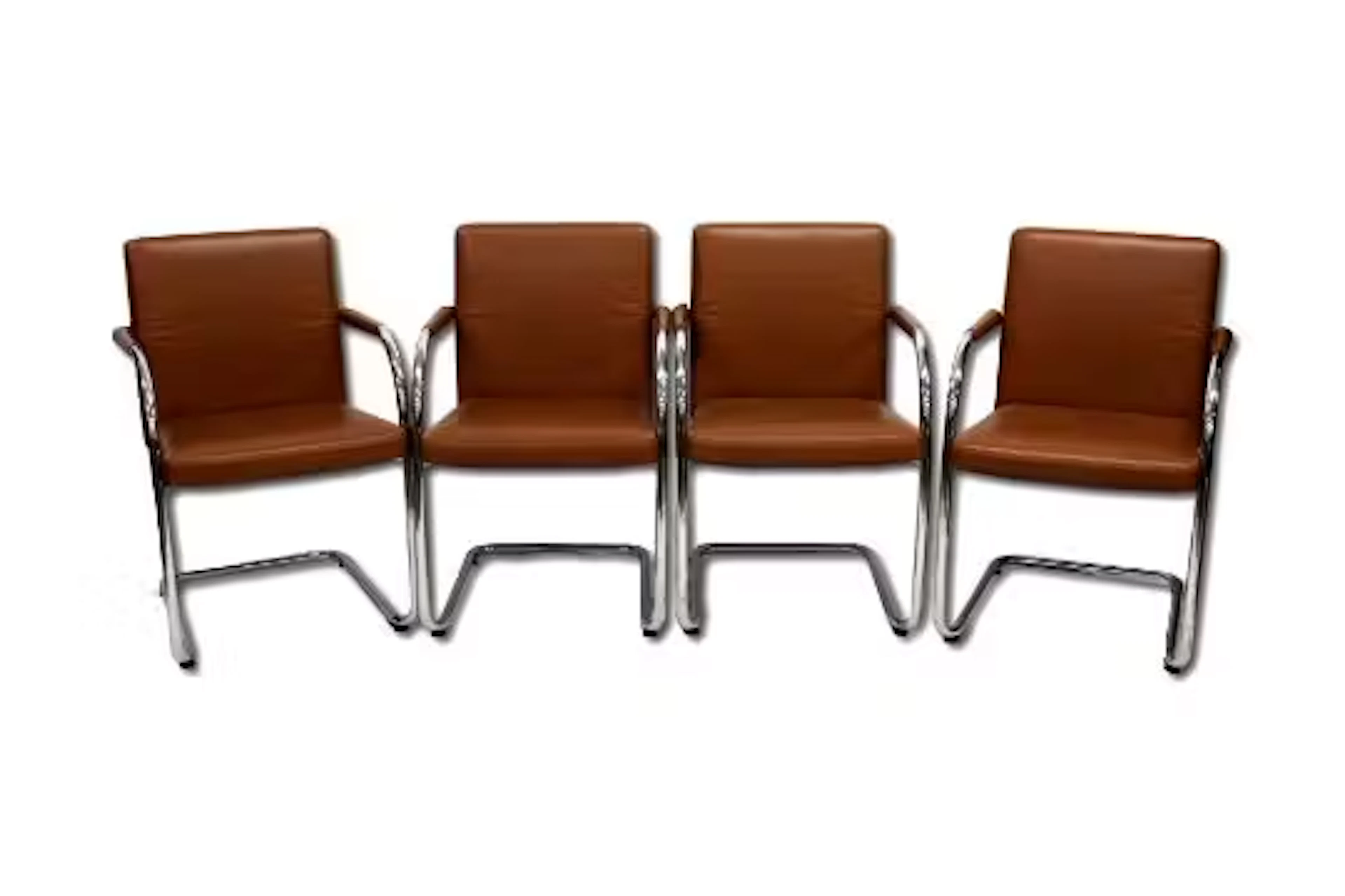 A set of four Vitra Visasoft stacking chairs, In brown leather and