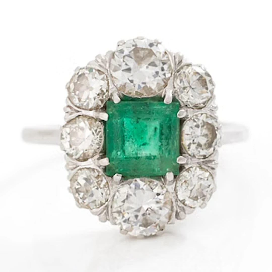 18K white gold ring set with a faceted emerald and round brilliant-cut