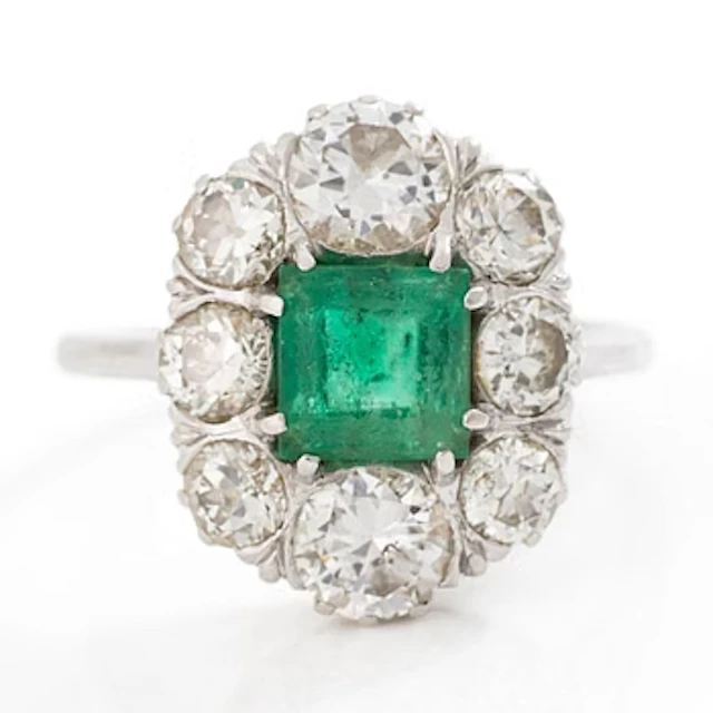 18K white gold ring set with a faceted emerald and round brilliant-cut