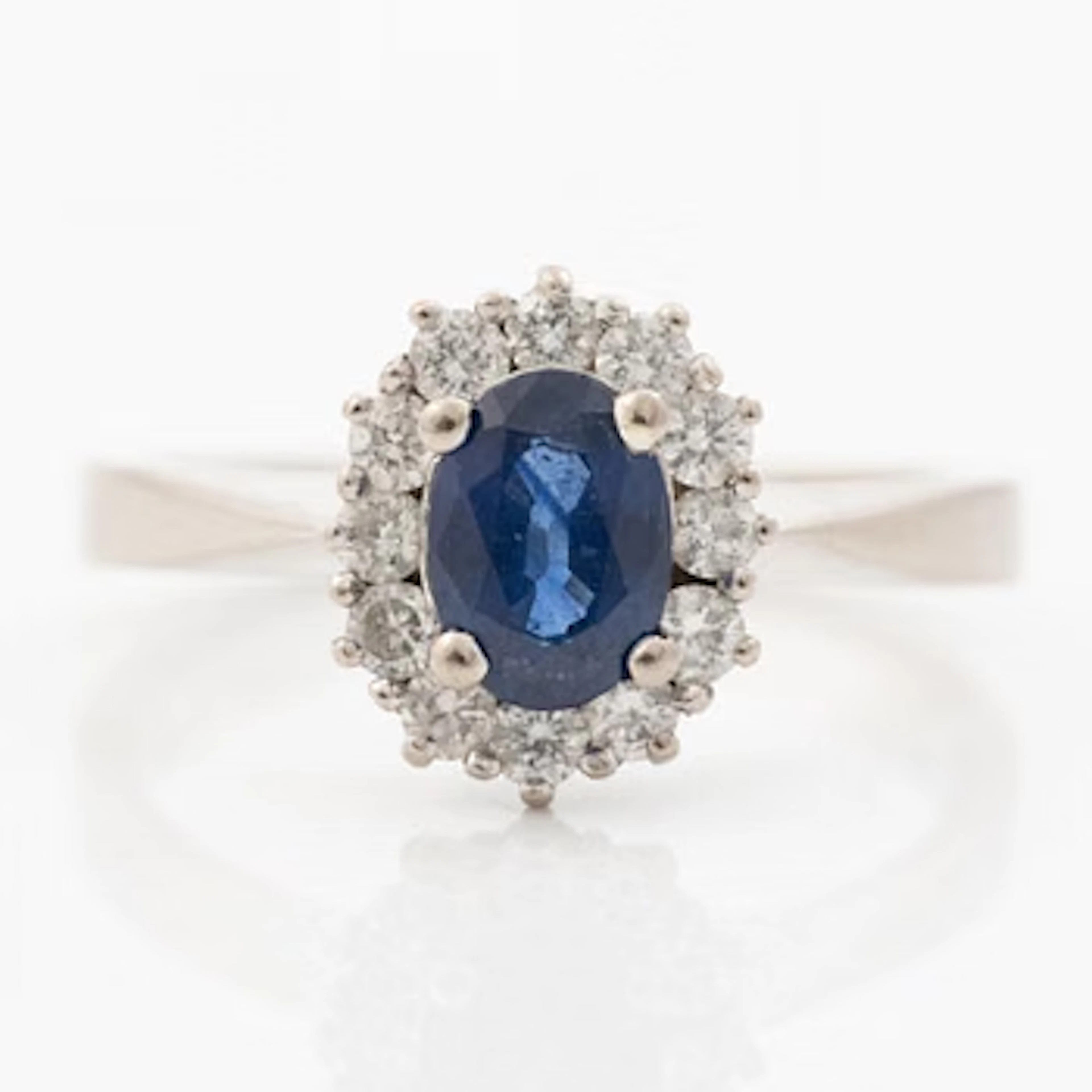 18K white gold ring with a blue sapphire and round brilliant-cut diamonds.