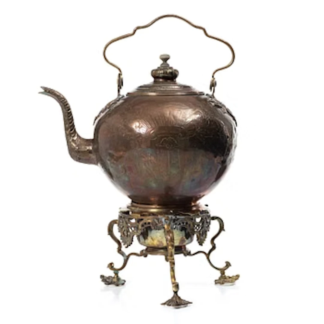 A German Rococo repoussé copper teapot on rechaud, mid 18th century.
