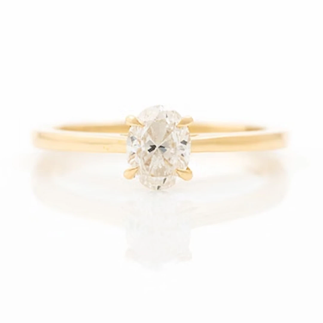 18K gold ring set with an oval-cut diamond weighing 0.72 ct, accompanied