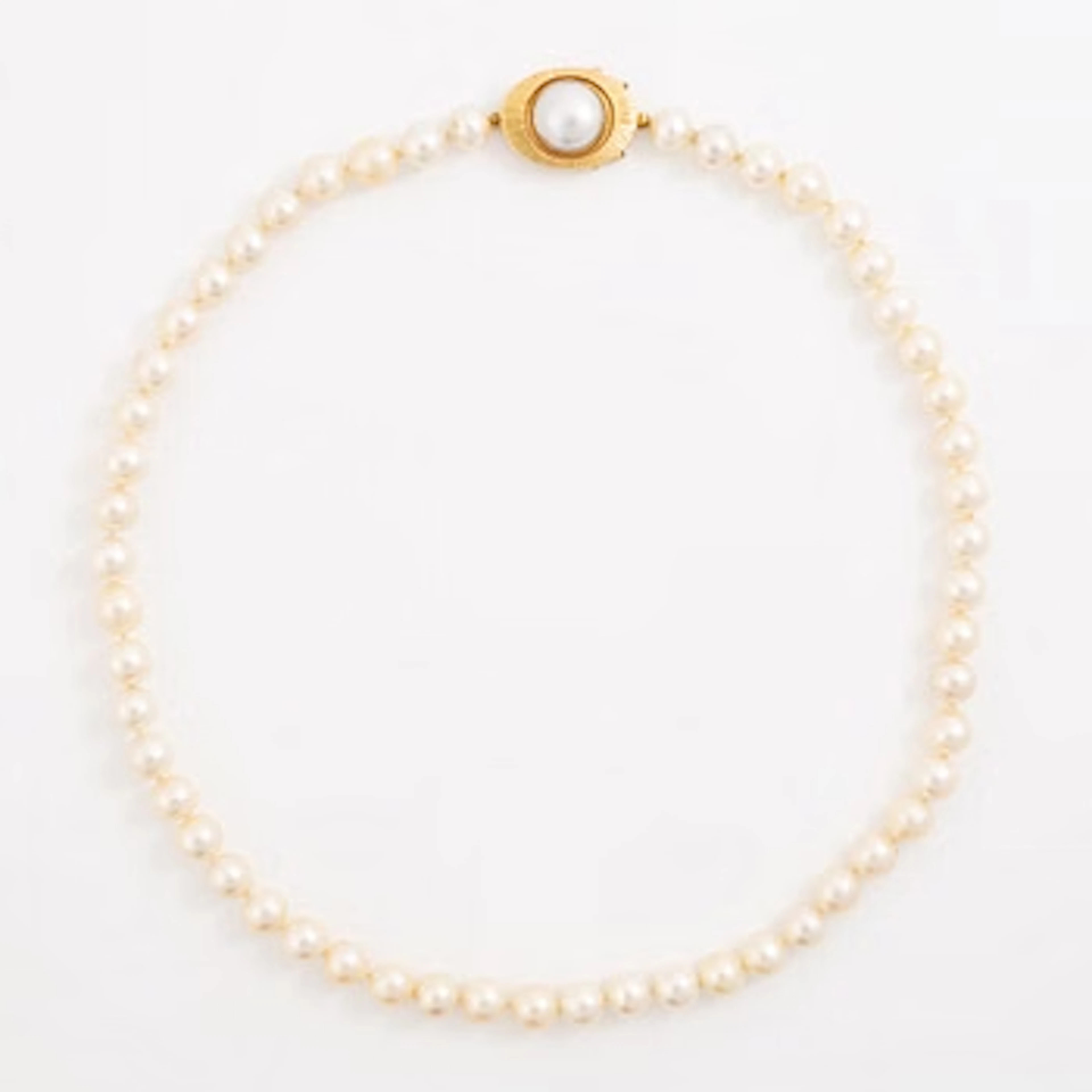 Necklace of cultured pearls with a cultured mabé pearl clasp in 18K gold.