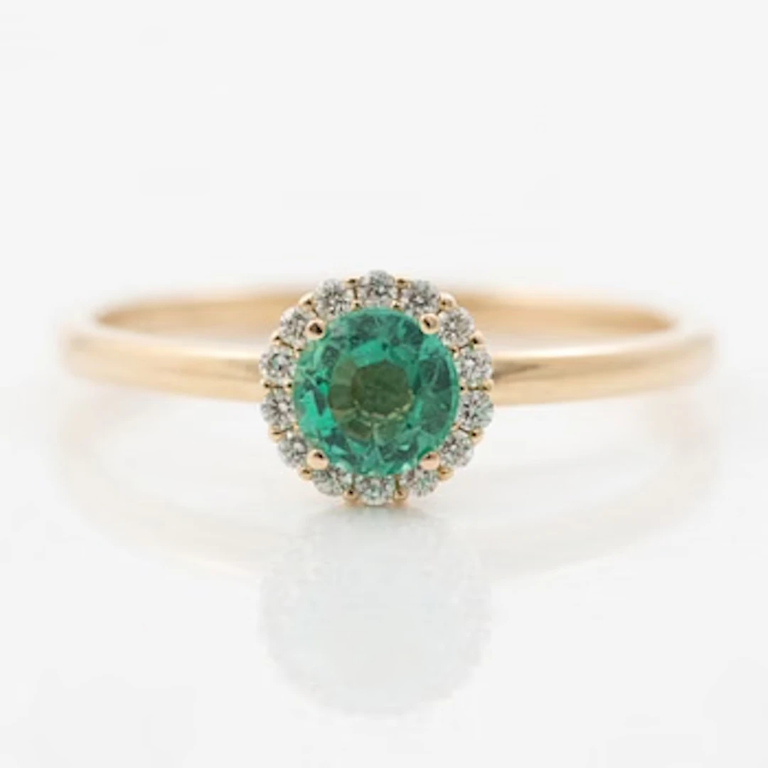 Ring in 14K gold with an emerald and small brilliant-cut diamonds.