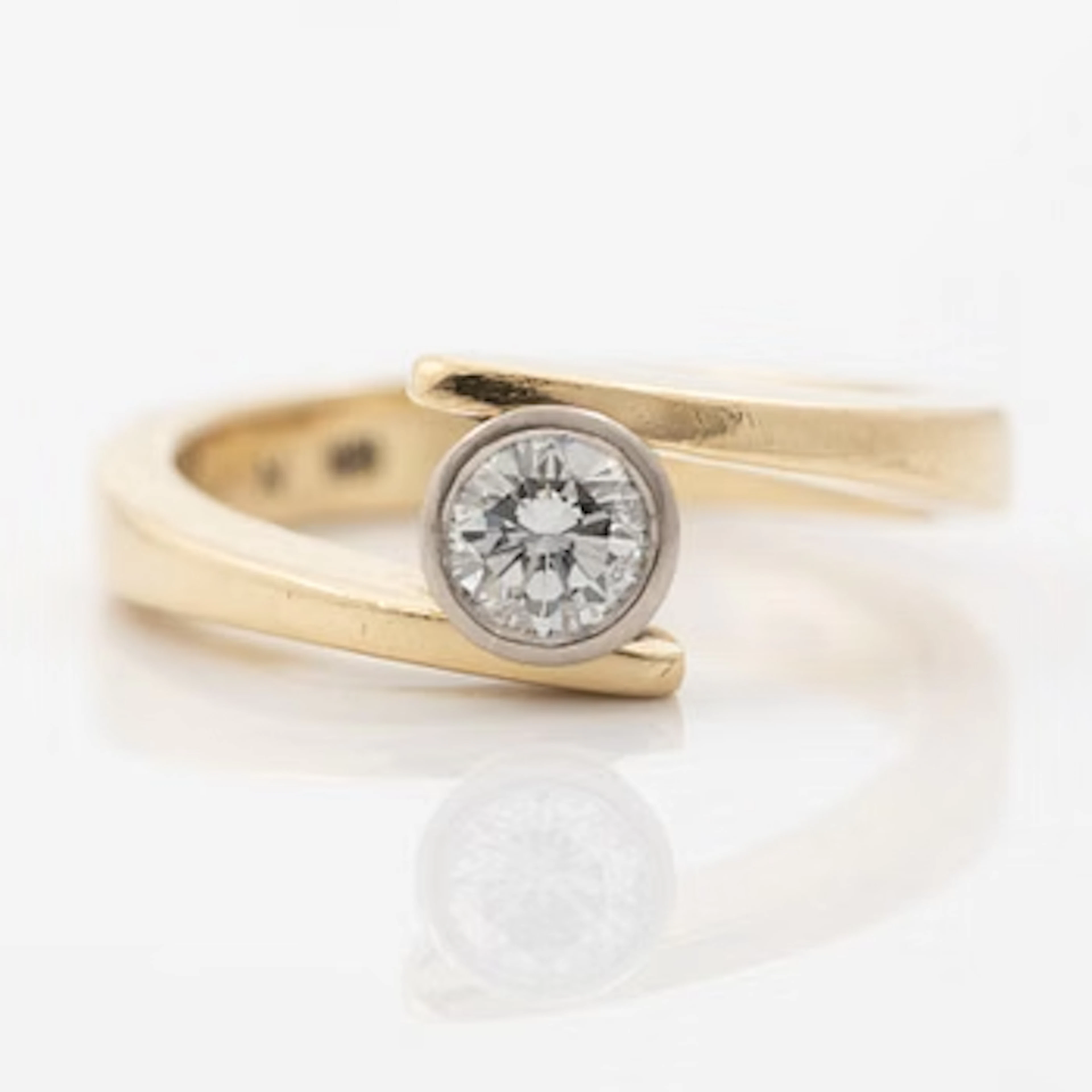 18K gold ring with a round brilliant-cut diamond.
