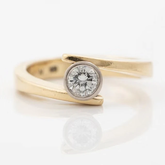 18K gold ring with a round brilliant-cut diamond.