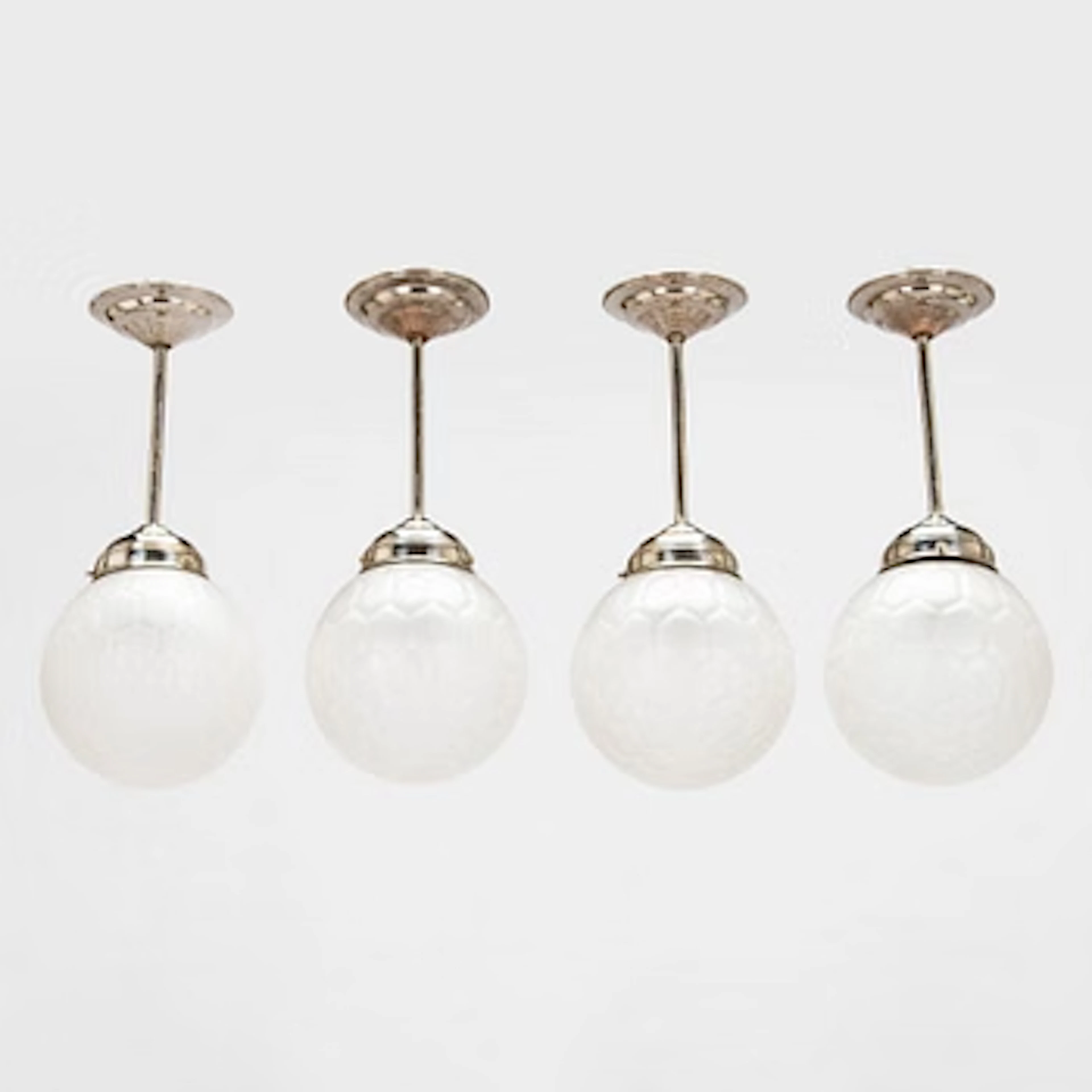 Four early 20th century pendant lights.