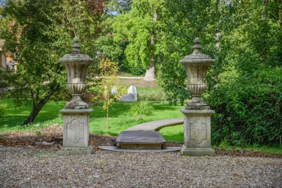 A MONUMENTAL PAIR OF ITALIAN LIMESTONE URN FINIALS ON PEDESTALS, 20TH CENTURY