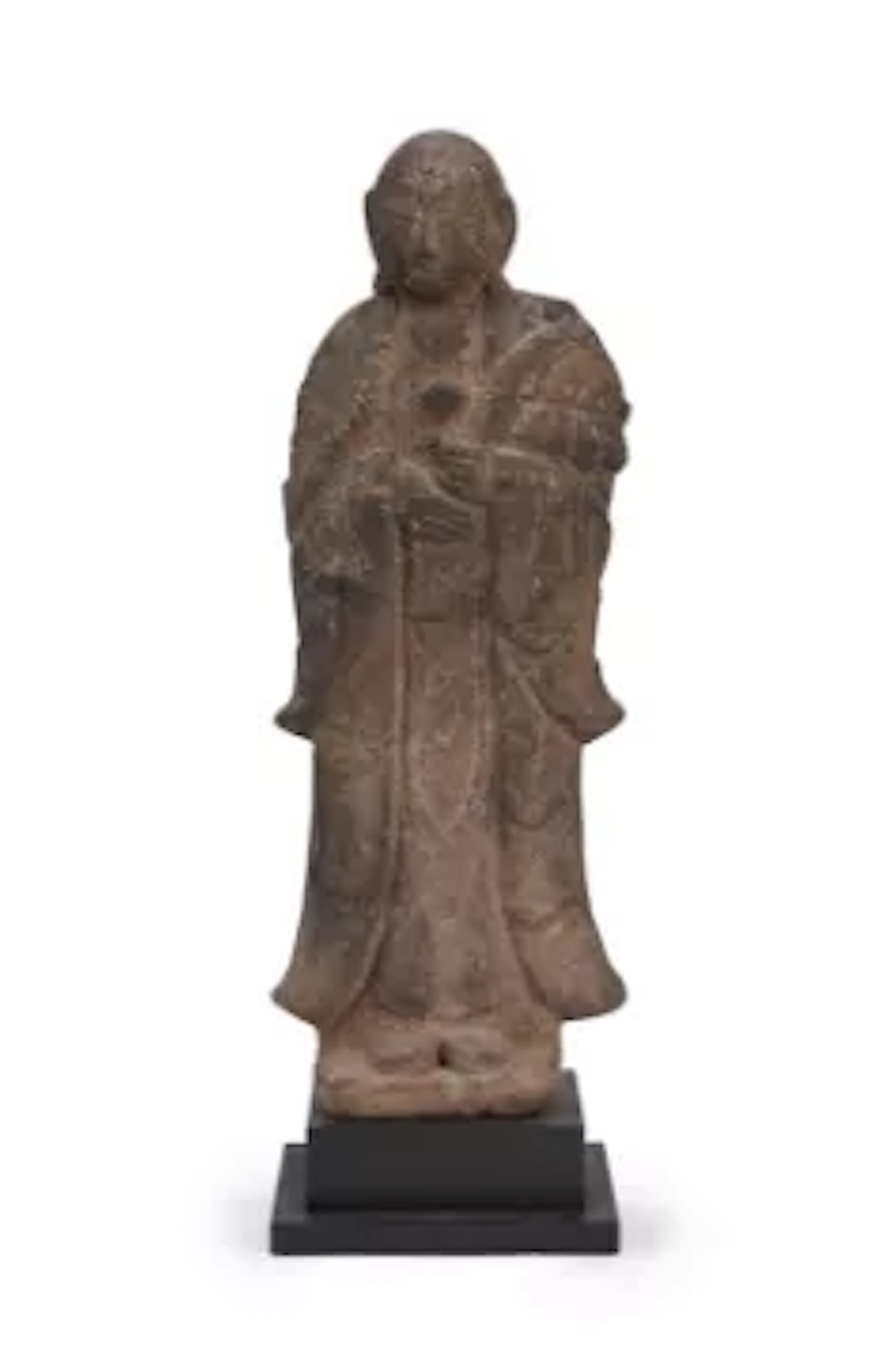 A large carved stone figure of a standing monk