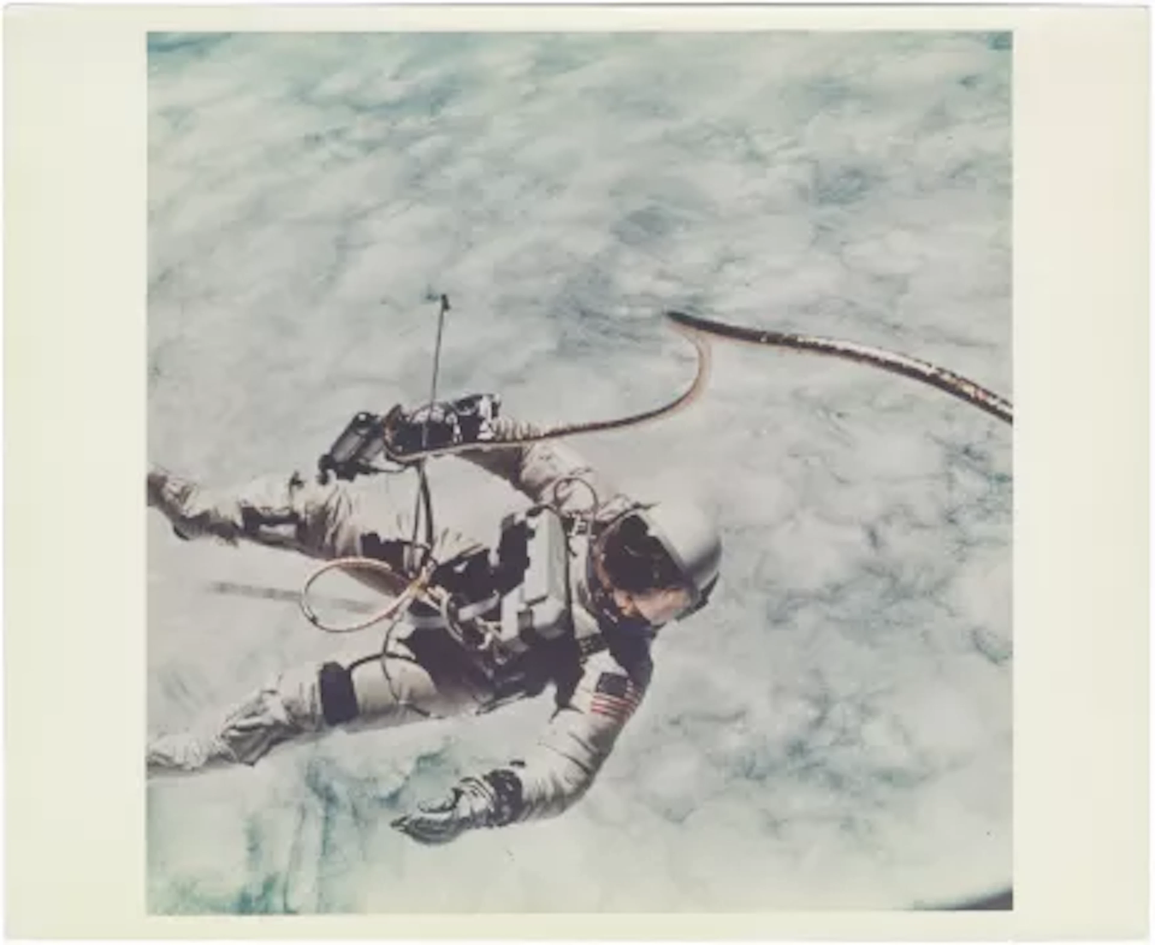 [Gemini IV] FIRST U.S. SPACEWALK: ED WHITE FLOATING OVER CLOUDS ABOVE