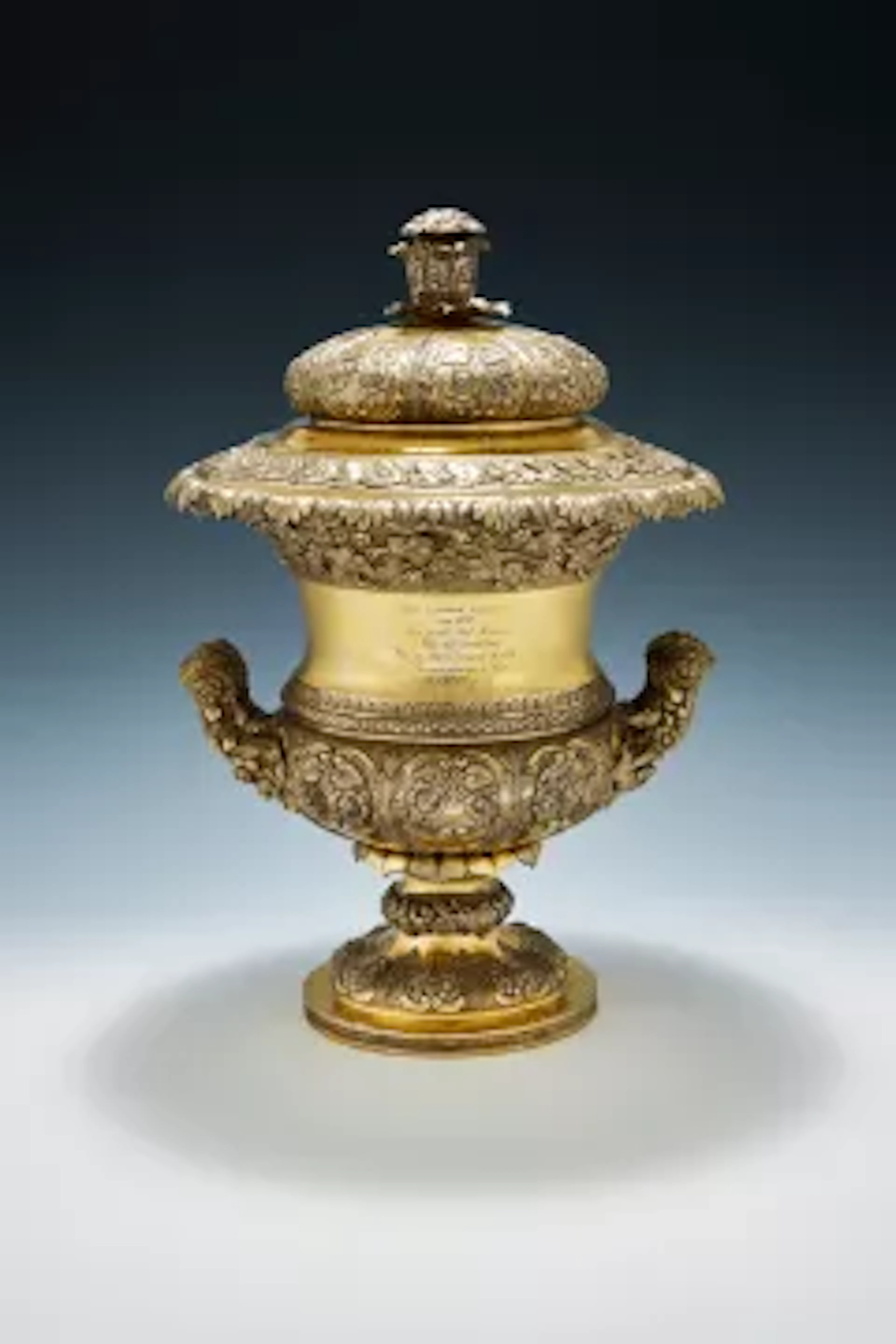 AN INDIAN COLONIAL SILVER GILT TWIN HANDLED TROPHY CUP AND COVER
