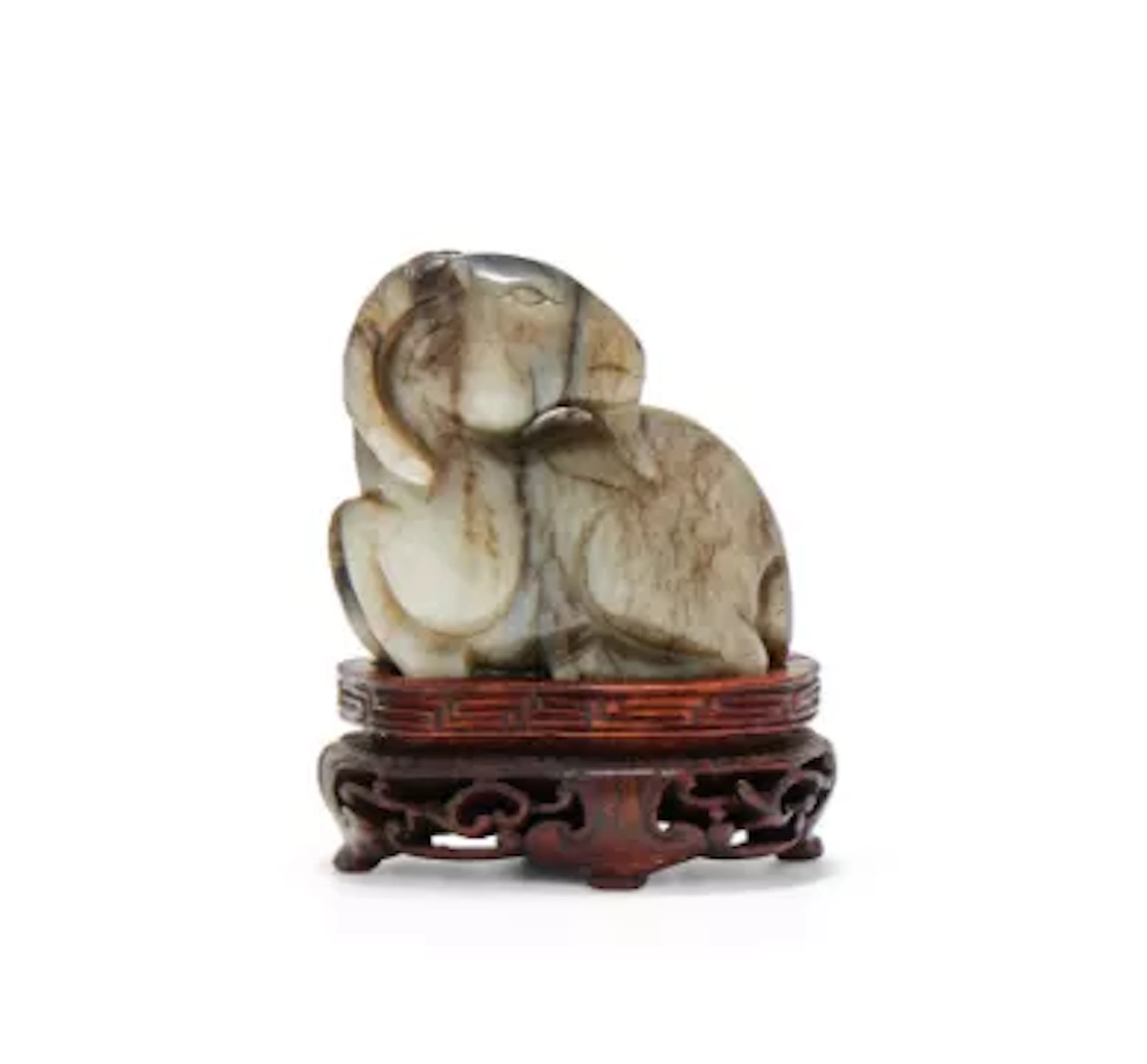 A Chinese celadon and brown and black jade model of a ram, Ming dynasty