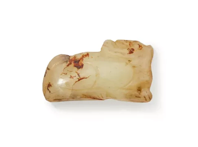 A Chinese pale celadon jade carving of a recumbent beast, Ming Dynasty