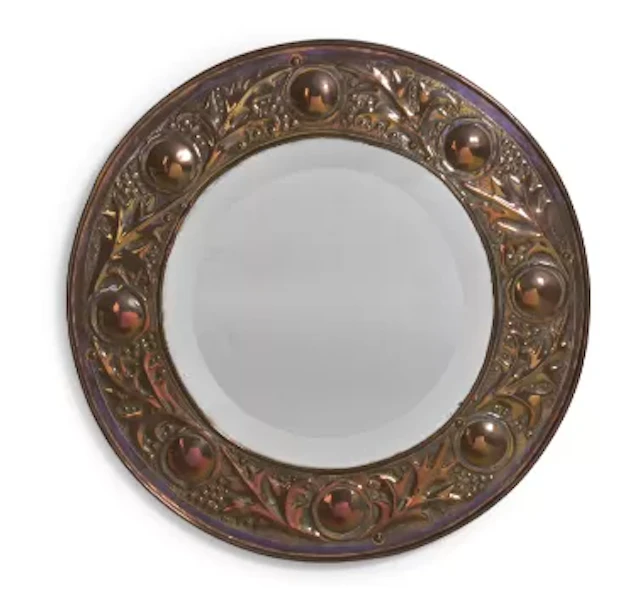 AN ARTS & CRAFTS EMBOSSED CIRCULAR WALL MIRROR, CIRCA 1900