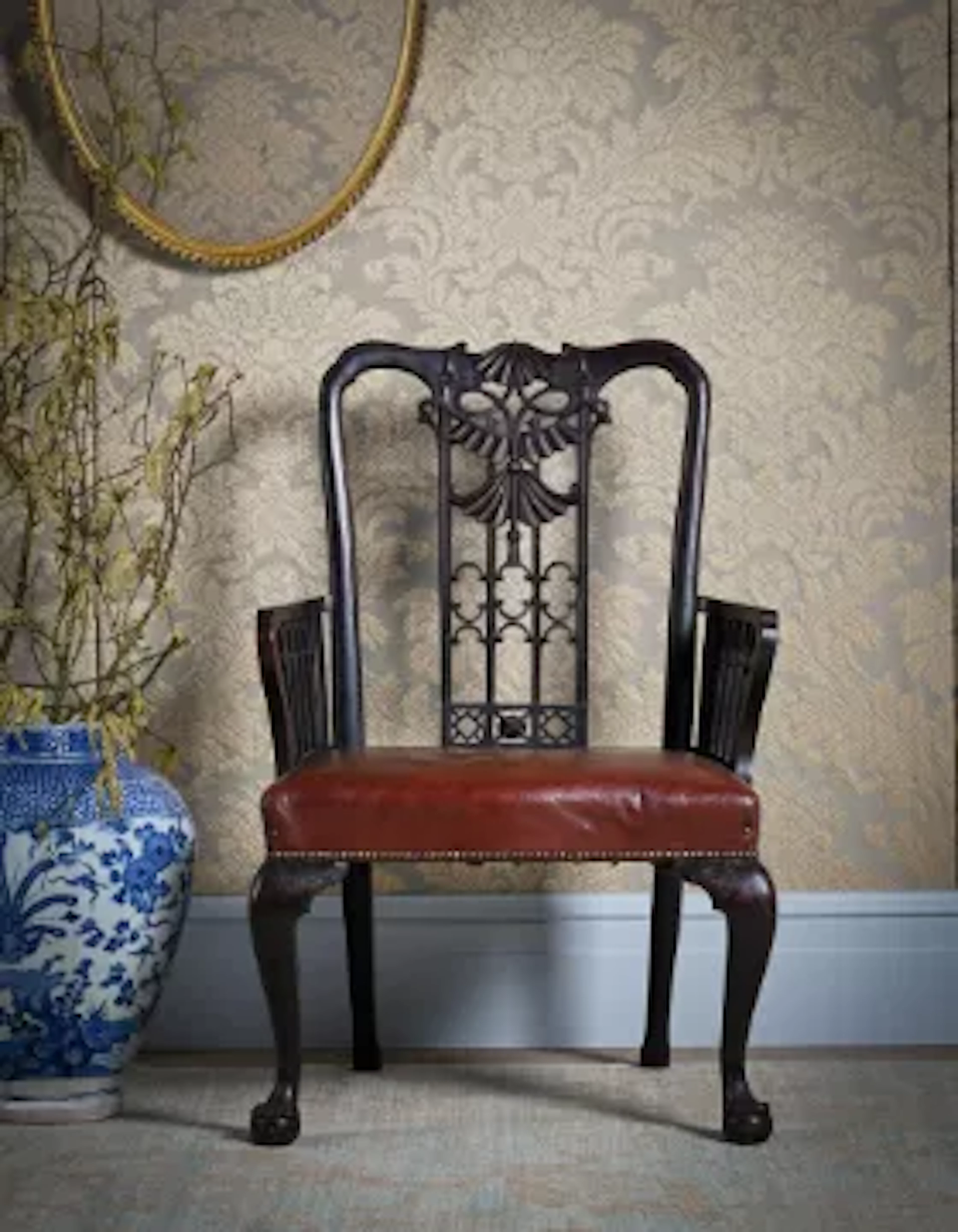 AN UNUSUAL CARVED MAHOGANY AND LEATHER UPHOLSTERED OPEN ARMCHAIR, 19TH CENTURY