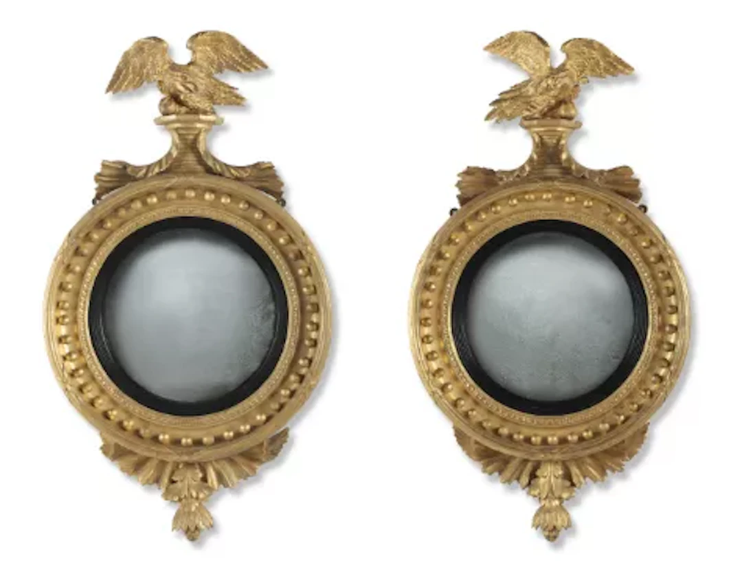A PAIR OF OPPOSING REGENCY GILTWOOD AND PARTLY EBONISED CONVEX MIRRORS