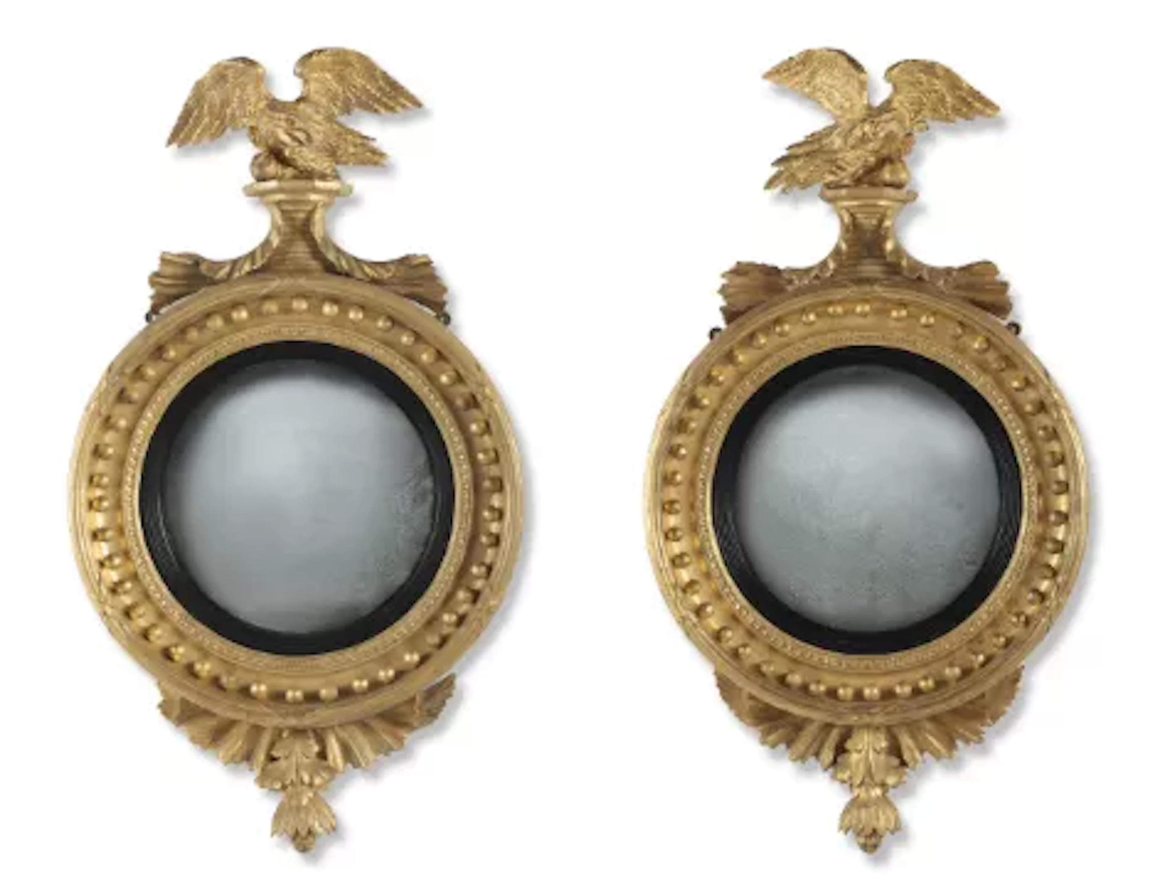 A PAIR OF OPPOSING REGENCY GILTWOOD AND PARTLY EBONISED CONVEX MIRRORS