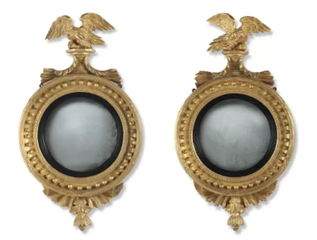 A PAIR OF OPPOSING REGENCY GILTWOOD AND PARTLY EBONISED CONVEX MIRRORS