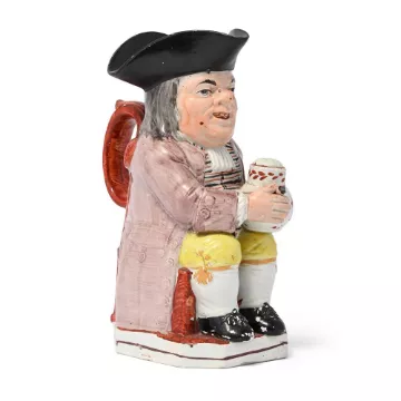 A STAFFORDSHIRE PEARLWARE PIPE-SMOKING TOBY JUG, CIRCA 1830