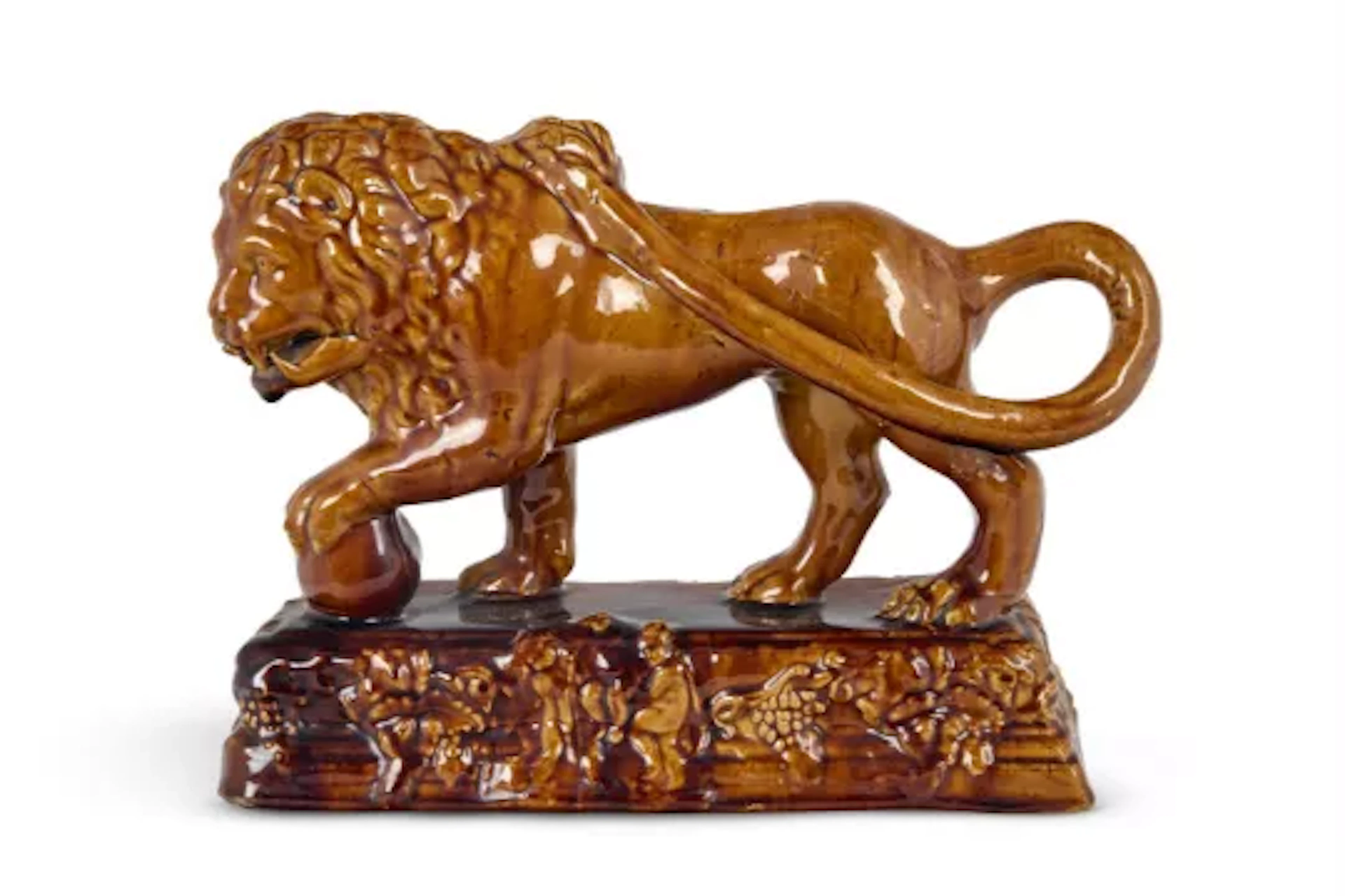 A STAFFORDSHIRE TREACLE-GLAZED POTTERY MODEL OF A MEDICI LION, MID 19TH CENTURY