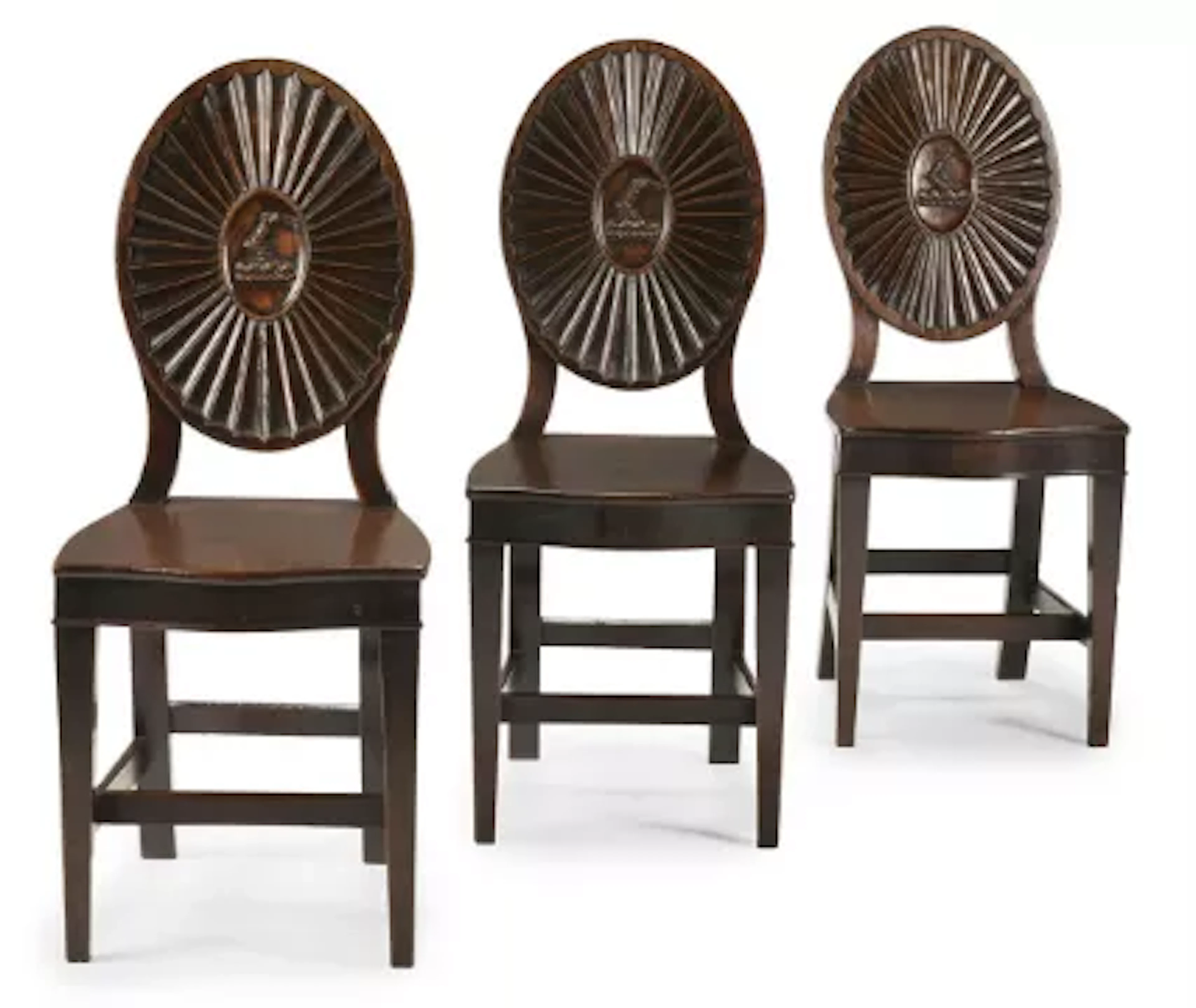 A SET OF THREE GEORGE III CARVED MAHOGANY HALL CHAIRS, IN THE MANNER