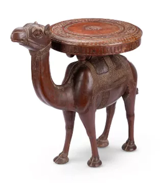 AN ANGLO INDIAN CARVED TEAK OCCASIONAL TABLE MODELLED AS A CAMEL, CIRCA 1900