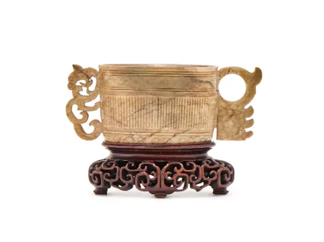 A Chinese pale celadon archaistic twin handled cup, Song or Ming Dynasty