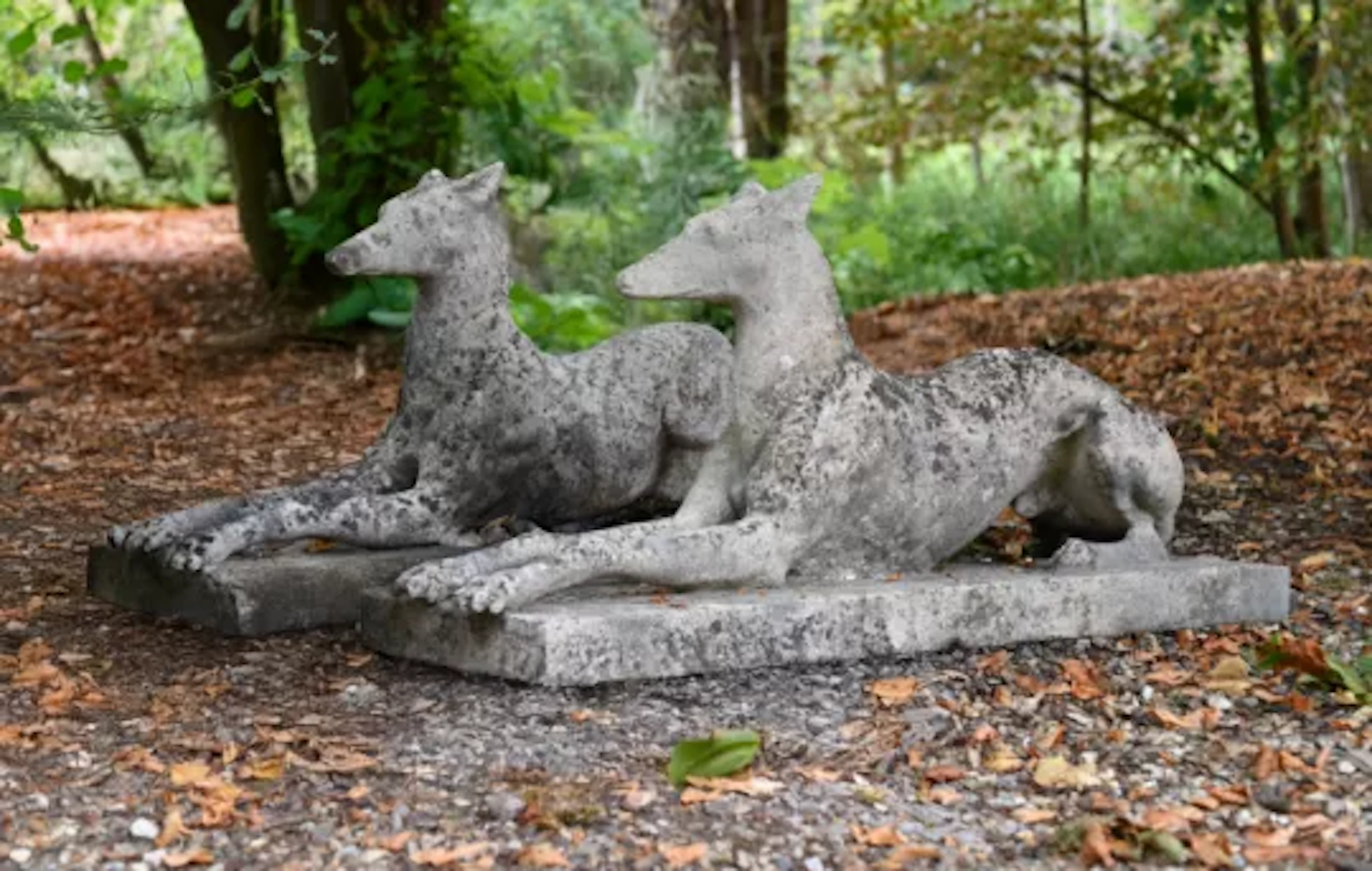 A PAIR OF ARTIFICIAL STONE RECUMBENT GREYHOUNDS, ATTRIBUTED TO AUSTIN
