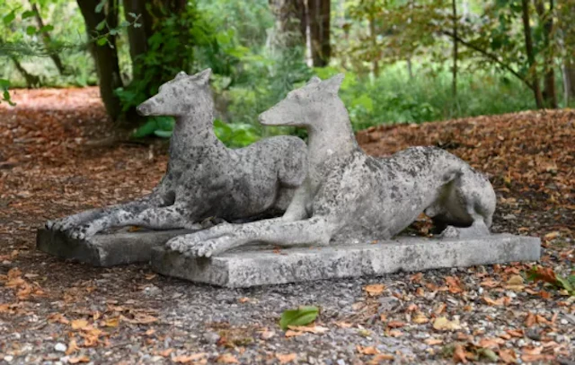 A PAIR OF ARTIFICIAL STONE RECUMBENT GREYHOUNDS, ATTRIBUTED TO AUSTIN