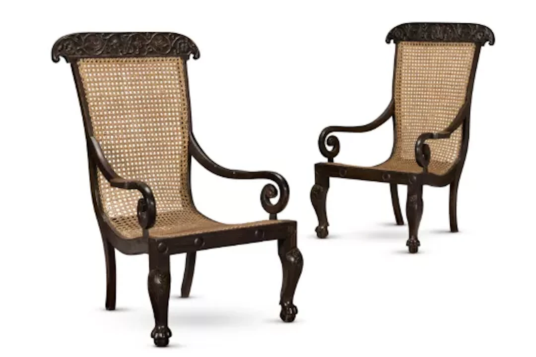 Y‡ A PAIR OF CEYLONESE EBONY AND CANED ARMCHAIRS, 19TH CENTURY